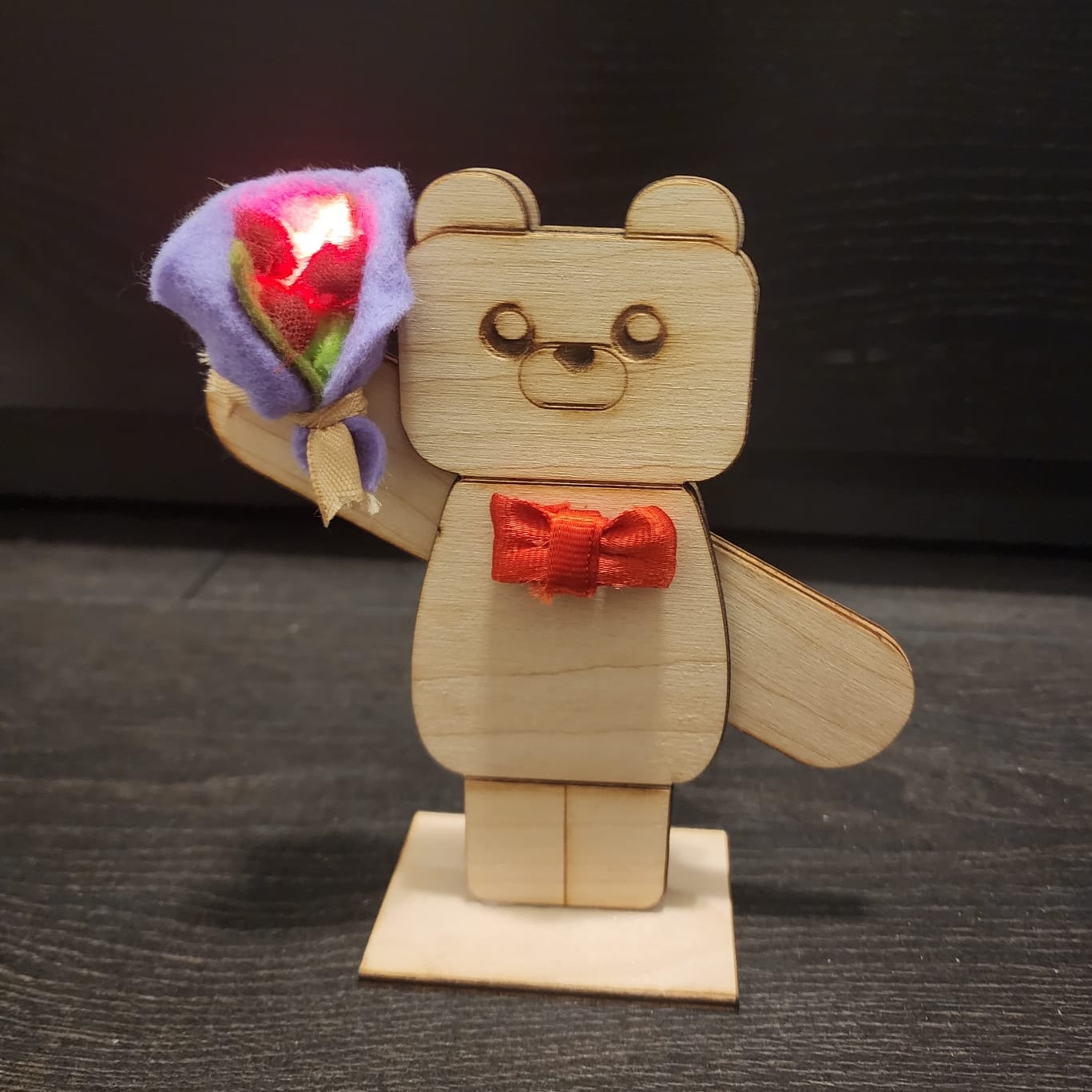 Bear holding up a bouquet of roses tht lights up