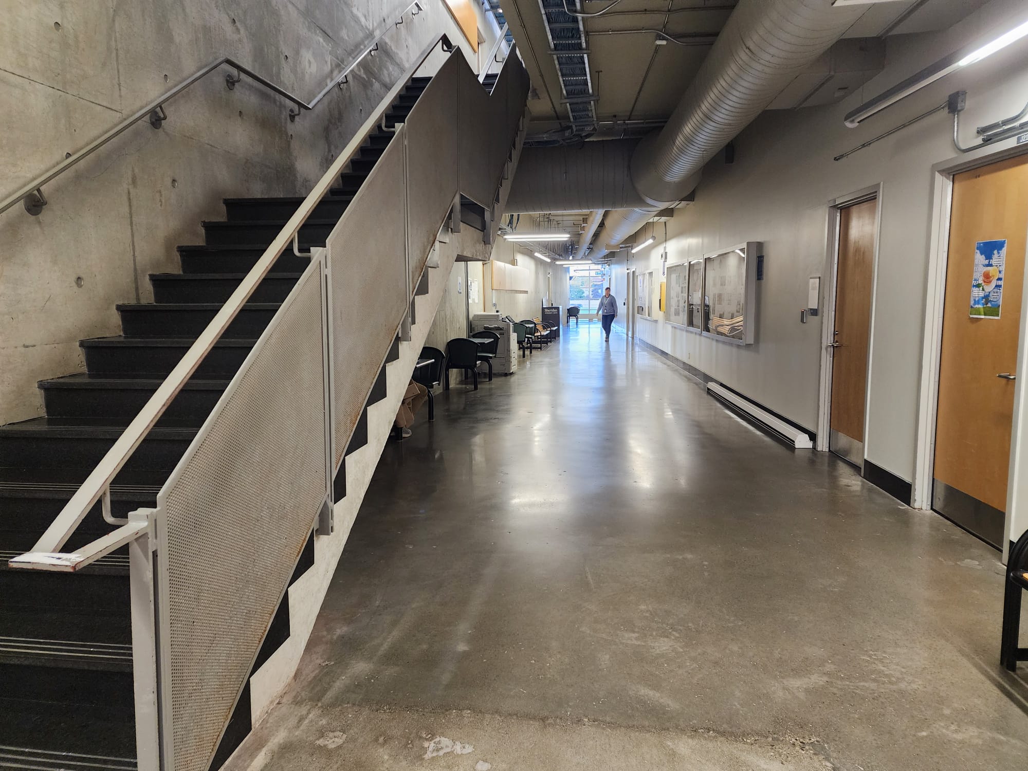 The J-wing second floor has a very industrialized and brutalist design, the floor, stairs, walls, and ceilings are all concrete, with the exception of the wooden doors. The doors being wooden creates good contrast between the rest of the space and it has few wooden benches and seating areas with metal chairs and small tables. 